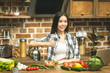 © denis_vermenko - Young cooking woman standing near desk smiling, looking at camera, shows thumbs up