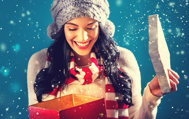 Wall Mural - Happy young woman opening a Christmas present box