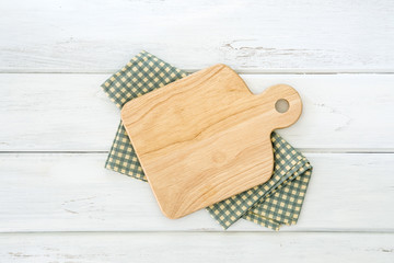 Sticker - Wooden cutting board on napkin placed on a white wooden table ,top view or overhead shot , food menu card or recipes background concept