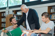 © auremar - teacher helping handicapped student with his homework at school