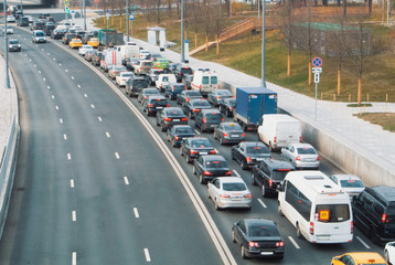 A view to a road with plenty of cars standing at traffic jam on a narrow street in the center of Moscow, Russia.