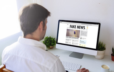 Poster - man reading fake news on computer