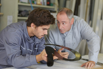 Wall Mural - engineer checking trainees work on factory floor