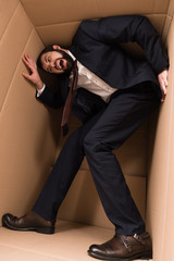 stressed businessman in cardboard box