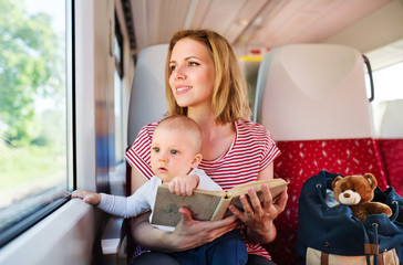 Young mother travelling with baby by train.