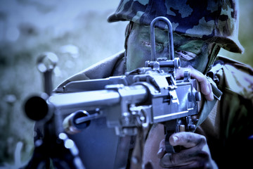 Soldier with a machine gun lying on the ground