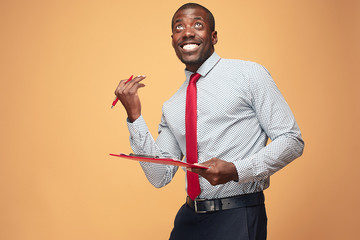 Attractive standing Afro-American businessman writing notes