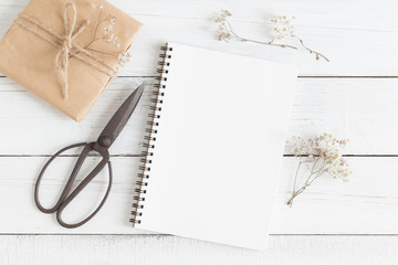 Wall Mural - flat lay photo of blank whtie notebook and scissors on whtie table