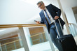 © goodluz - Businessman with suitcase at airport departure hall
