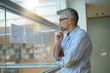 © goodluz - Businessman analyzing results charts hanged on office window
