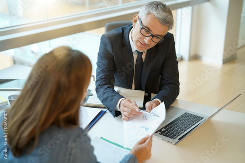 Photographie Woman in banker's office signing financial loan for project