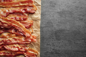 Parchment with cooked bacon rashers on table