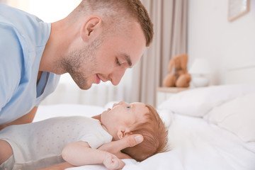 Wall Mural - Young father with baby on bed at home