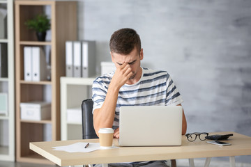 Wall Mural - Tired man with laptop at home