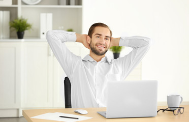 Wall Mural - Attractive man with laptop in office