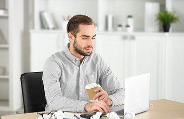 Wall Mural - Attractive man with laptop in office