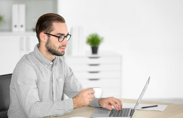 Wall Mural - Attractive man with laptop in office