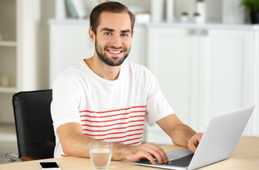 Wall Mural - Attractive man with laptop in office