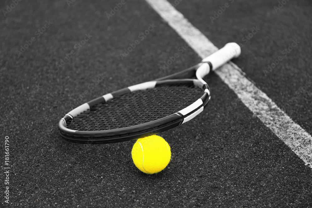 Tennis racket and ball on court