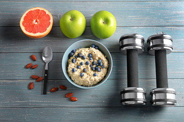 Wall Mural - Composition with tasty oatmeal in bowl on wooden background