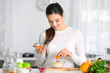 © Africa Studio - Young woman preparing oatmeal porridge on table in kitchen