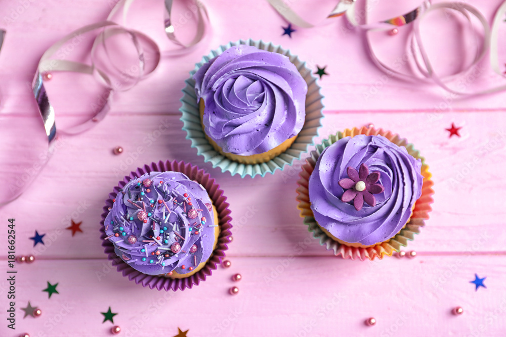 Tasty colorful cupcakes on wooden table