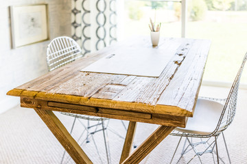 Artist wooden table with drawing boars and chairs by sunny window in house, home or apartment