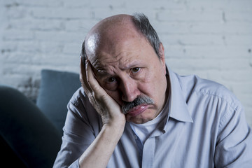 Wall Mural - portrait of senior mature old man on his 60s at home couch alone feeling sad and worried suffering pain and depression