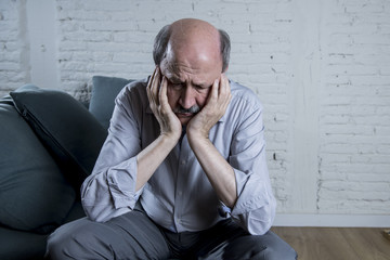 Wall Mural - portrait of senior mature old man on his 60s at home couch alone feeling sad and worried suffering pain and depression