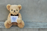 Fototapeta  - Bear hold paper that has blue heart.