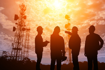 Silhouette Teams engineer looking Telecommunication mast television antennas on sunlight