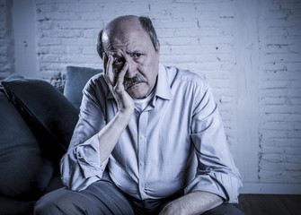 Wall Mural - portrait of senior mature old man on his 60s at home couch alone feeling sad and worried suffering pain and depression