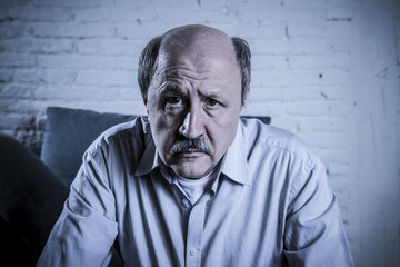 Wall Mural - portrait of senior mature old man on his 60s at home couch alone feeling sad and worried suffering pain and depression