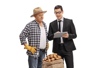 Poster - Businessman showing something on a tablet to a farmer with a burlap sack