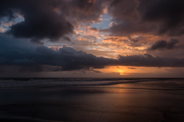 Wall Mural - dramatic sunset clouds reflected on the water sea. tropical beach landscape at golden hour