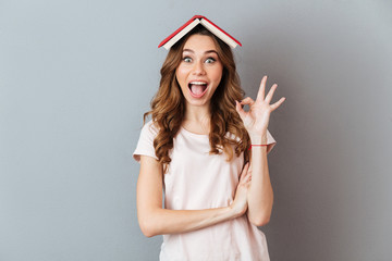 Poster - Portrait of an excited girl holding book on her head