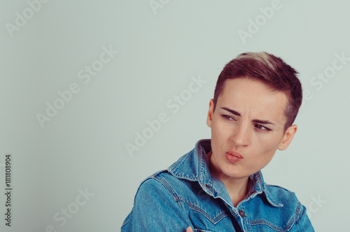 Fotografia, Obraz Closeup portrait skeptical young woman looking suspicious, some disgust on her face mixed with disapproval isolated green white grey background