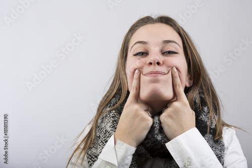 Donna bionda con camicia bianca su sfondo bianco ci fa il gesto ...