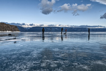 Wall Mural - people stand on the ice of lake Baikal and take pictures