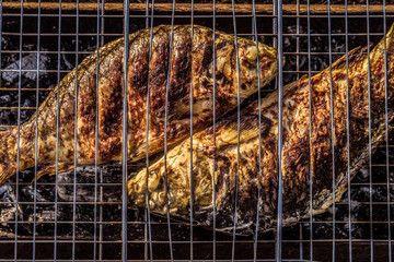 Baked on charcoal grill fish. Cooked carp.