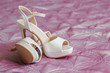 © Aliaksandr Marko - bride's biege shoes on heel on a carpet.