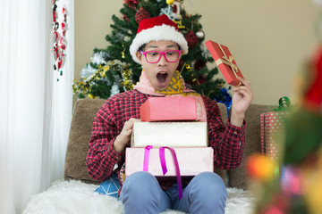 Attractive man with many present boxes sitting at home.