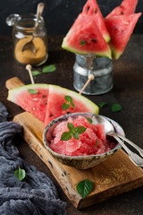 Wall Mural - Fresh watermelon cut into pieces and holding granite on  gray stone background. Selective focus.