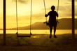 © bohbeh - Silhouette of child enjoying the swing outdoors with river and mountain view