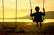 © bohbeh - Silhouette of child enjoying the swing outdoors with river and mountain view