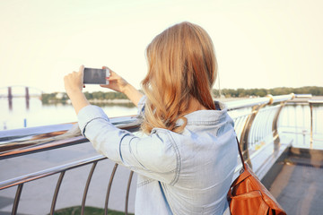 Young female tourist taking photo outdoors