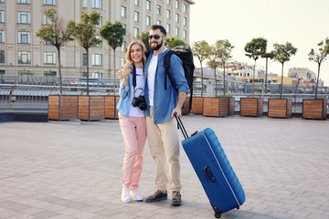 Wall Mural - Couple of young tourists with luggage outdoors