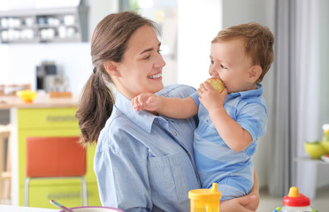 Poster - Young woman holding her baby at home