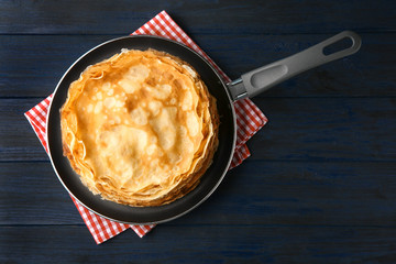 Canvas Print - Frying pan with stack of delicious thin pancakes on wooden table