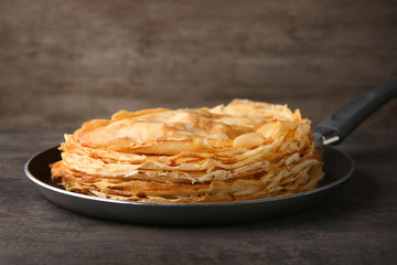 Sticker - Frying pan with stack of delicious thin pancakes on wooden table